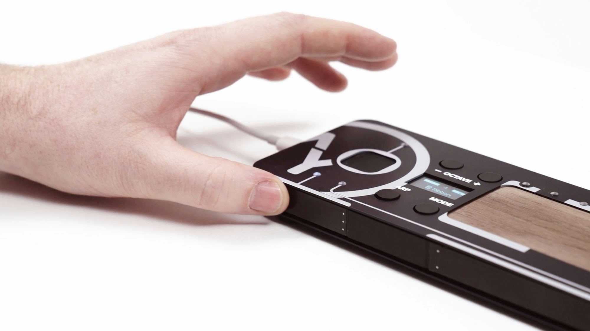 A hand touching the front slider of the Loom.